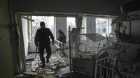Prajurit Ukraina bekerja di dalam rumah sakit bersalin yang rusak akibat serangan udara di Mariupol, Ukraina (9/2/2022). Serangan Rusia telah merusak parah sebuah rumah sakit bersalin di kota pelabuhan Mariupol yang terkepung, kata pejabat Ukraina. (AP Photo/Evgeniy Maloletka)