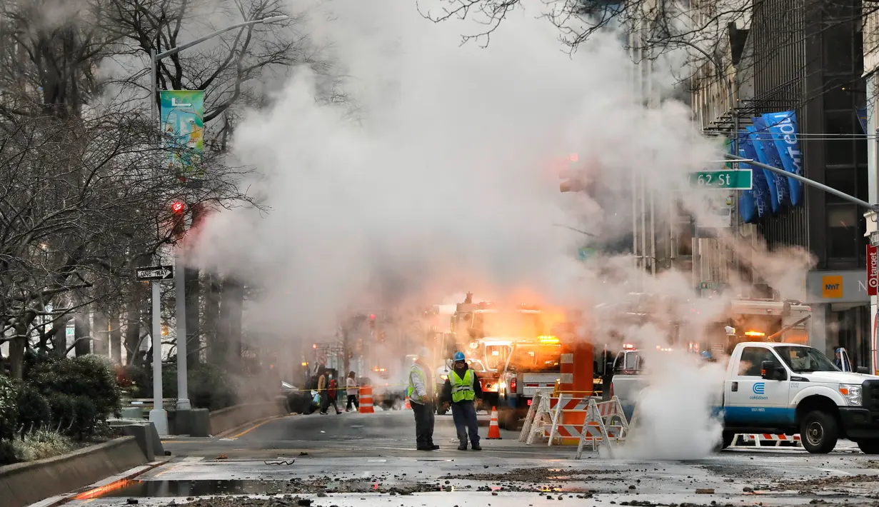 Asap mengepul dari jalan saat sejumlah kendaraan terpaksa berhenti karena banjir di New York, Amerika Serikat, Senin (13/1/2020). Banjir diakibatkan rusaknya saluran air utama yang berdiameter tiga kaki. (AP Photo/Richard Drew)