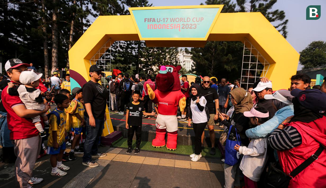 Beberapa pengunjung berfoto bareng dengan maskot Piala Dunia U-17, Bacuya dalam rangkaian acara Trophy Tour Experience menyambut Piala Dunia U-17 2023 di Cikapayang Dago Park, Bandung, Minggu (22/10/2023) pagi WIB. (Bola.com/Bagaskara Lazuardi)