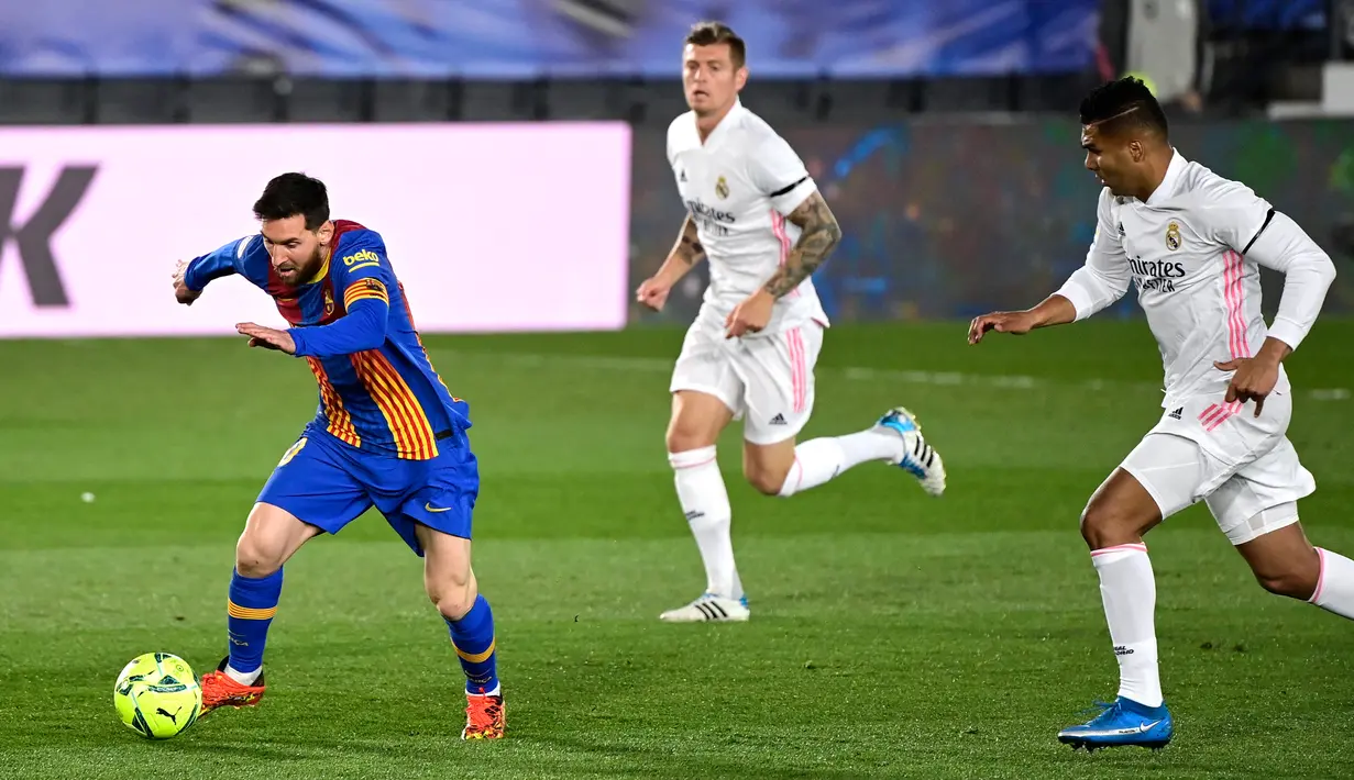 Dari kiri) Gelandang Real Madrid, Casemiro dan Toni Kroos menantang pemain depan Barcelona Lionel Messi pada pekan ke-30 Liga Spanyol di Estadio Alfredo Di Stefano, Minggu dinihari WIB (11/4/2021). Real Madrid kembali sukses taklukkan rival abadinya Barcelona 2-1. (JAVIER SORIANO / AFP)