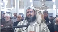 Video viral seekor kucing memanjat pundak imam sholat tarawih, Sheikh Walid Mehsas, di Aljazair. (Video: Screencapture Instagram @reuters).