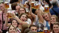Para wanita muda mengangkat gelas bir saat pembukaan festival bir terbesar di dunia Oktoberfest ke-185 di Munich, Jerman, Sabtu (22/9). (AP Photo/Matthias Schrader)