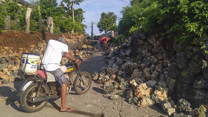 Seorang penduduk melihat kerusakan setelah gempa kembar berkekuatan magnitudo 5,4 dan 5,9 di Itbayat on Pulau Batanes, Filipina (27/7/2019). Banyak orang sedang tidur pulas ketika gempa pertama terjadi pada Sabtu (27/7./2019) pagi. (Agnes Salengua Nico via AP)