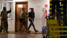 Tersangka teroris berjalan dikawal oleh polisi di hanggar Polisi Federal Brasil di bandara di Brasil, (21/7). Kepolisan Brasil menangkap 10 orang amatiran yang disebut seakan-akan telah menyatakan kesetiannya kepada ISIS.( AFP PHOTO/Evaristo SA)