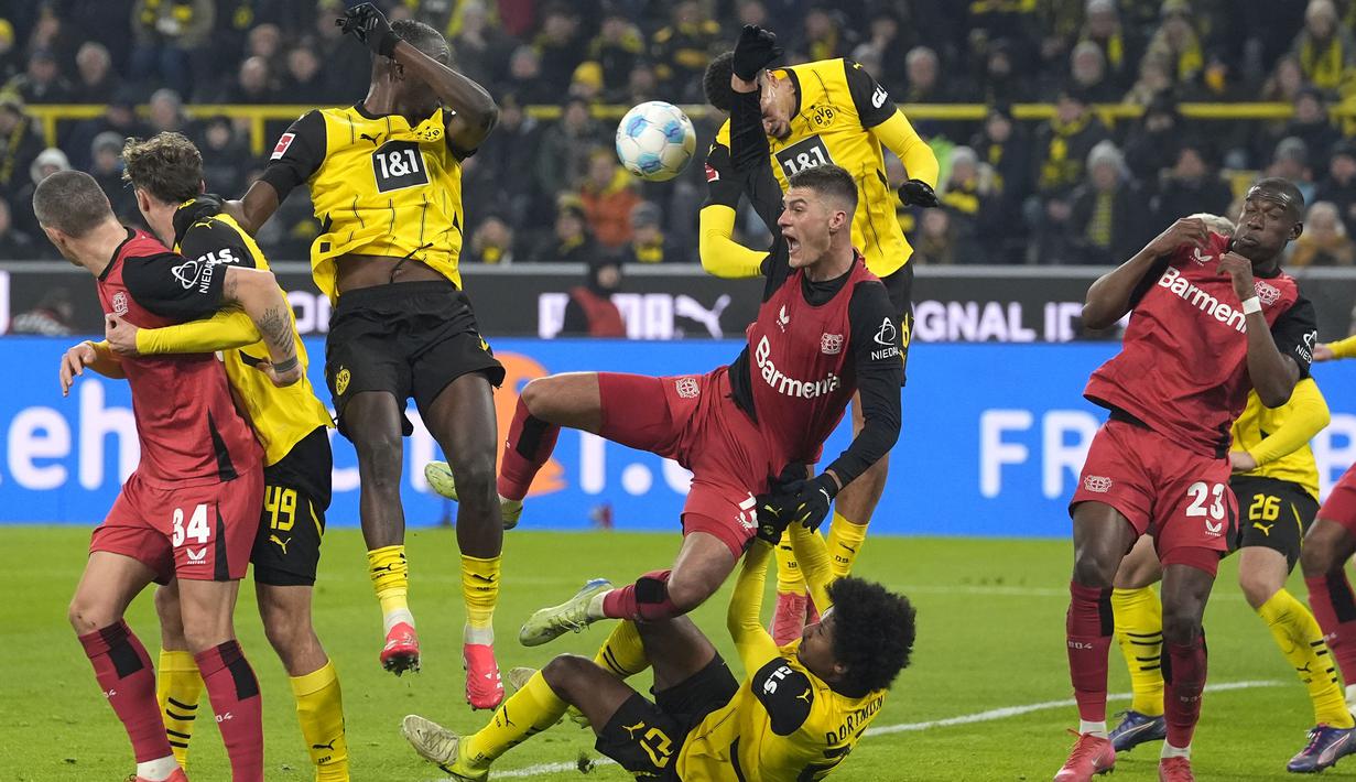 Pemain Bayer Leverkusen, Patrik Schick (tengah) berebut bola dengan pemain Borussia Dortmund, Karim Adeyemi pada laga lanjutan Bundesliga 2024/2025 di Signal Iduna Park, Dortmund, Jerman, Sabtu (11/01/2025) WIB. (AP Photo/Martin Meissner)