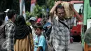 Pemudik memikul barang bawaannya saat tiba di Terminal Kampung Rambutan, Jakarta Timur, Sabtu (9/7). Puncak arus balik Lebaran diprediksi terjadi pada Sabtu- Minggu (9-10) Juli 2016. (Liputan6.com/Yoppy Renato)