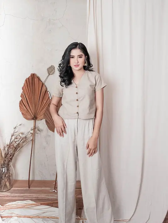 Ketika pemotretan, mantan personel JKT48 ini tampil dengan gaya kasual. Ia memilih mengenakan kemeja berwarna pastel yang dipadukan dengan celana panjang putih. Busana dan background studio pemotretan terlihat sangat cocok. (Liputan6.com/IG/@ochi24)