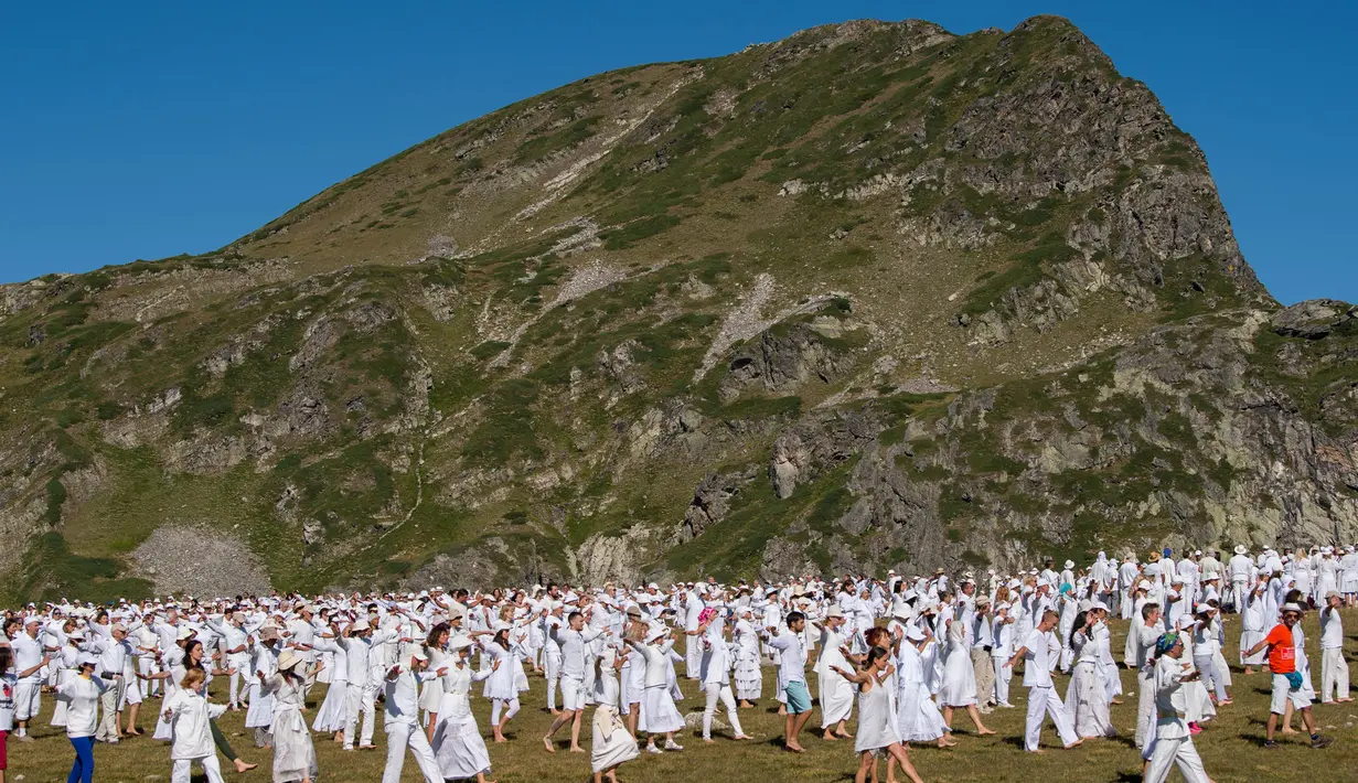 Anggota gerakan keagamaan internasional White Brotherhood menari di puncak Gunung Rila, Bulgaria, Senin (19/8/2019). Ratusan peziarah tersebut berkumpul di puncak Gunung Rila pada 19-21 Agustus untuk menandai tahun baru "spiritual" mereka. (NIKOLAY DOYCHINOV/AFP)