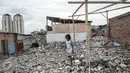 Seorang bocah melintas di dekat puing-puing di Kampung Akuarium, Penjaringan, Jakarta Utara, Senin (30/1). Saat ini ratusan warga masih tinggal di lokasi yang telah digusur oleh Pemprov DKI. (Liputan6.com/Gempur M Surya)