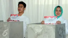 Calon Walikota Tangerang Selatan, Airin Rachmi Diany (kanan) menggunakan hak pilih bersama putra pertama TB Ghifari Wardana (kiri) di TPS 17 Serpong Utara, Tangerang Selatan, Banten, Rabu (9/12). (Liputan6.com/Helmi Afandi)
