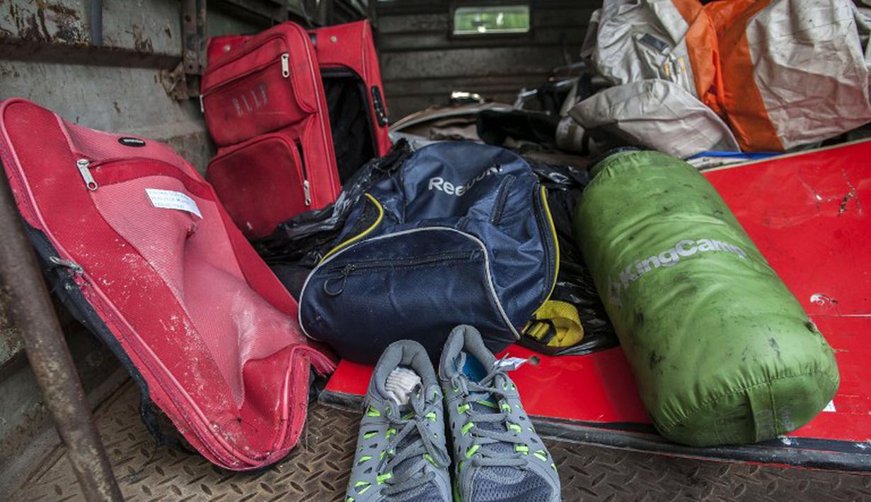 Barang pribadi milik penumpang AirAsia berhasil ditemukan Tim SAR, Bandara Juanda, Rabu (7/1/2015). (AFP Photo/Juni Kriswanto)