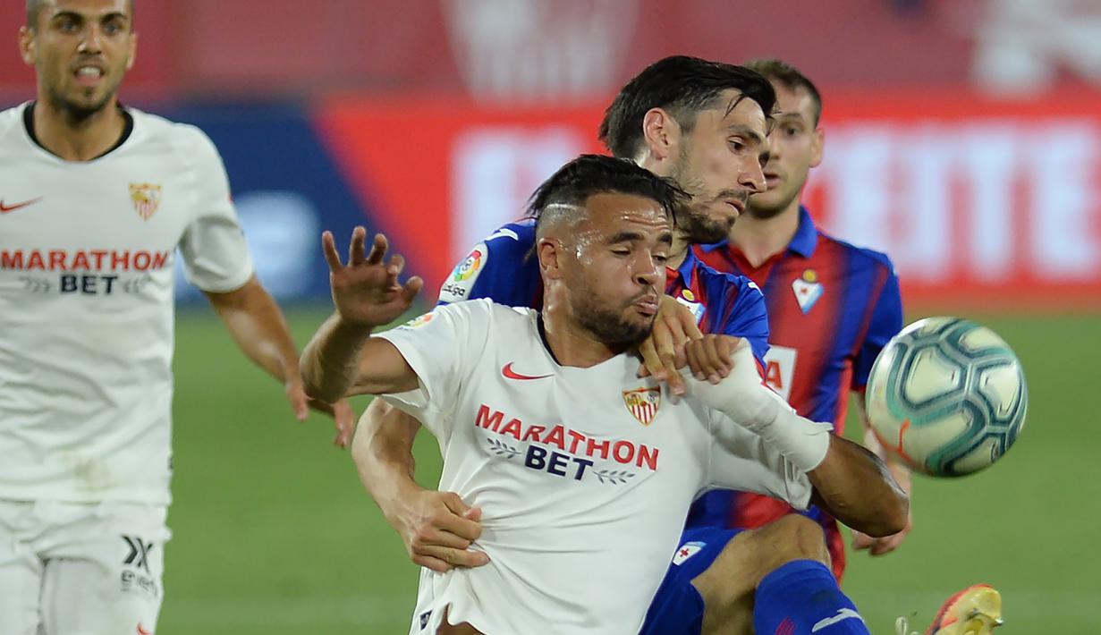 Penyerang Sevilla, Youssef En-Nesyri, berebut bola dengan bek Eibar, Paulo Oliveira, pada laga lanjutan La Liga pekan ke-34 di Estadio Ramon Sanchez Pizjuan, Selasa (7/7/2020) dini hari WIB. Sevilla menang 1-0 atas Eibar. (AFP/Cristina Quicler)