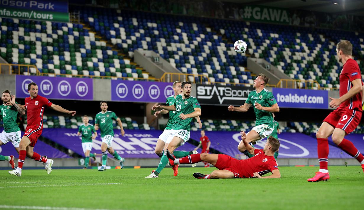 Bek Norwegia, Kristoffer Ajer, berebut bola dengan bek Irlandia Utara, Daniel Ballard, pada laga UEFA Nations League di Windsor Park, Selasa (8/9/2020) dini hari WIB. Norwegia menang telak 5-1 atas Irlandia Utara. (AFP/Paul Faith)