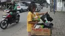 Seorang anak mengambil mi instan dan telur gratis di Jalan Raya Cibubur-Bojong Kulur, Bogor, Kamis (9/4/2020). Di beberapa pinggir jalan Kawasan Jabotabek saat ini banyak aksi solidaritas oleh warga dengan menyediakan bahan makanan gratis di tengah pandemi virus corona. (merdeka.com/Arie Basuki)