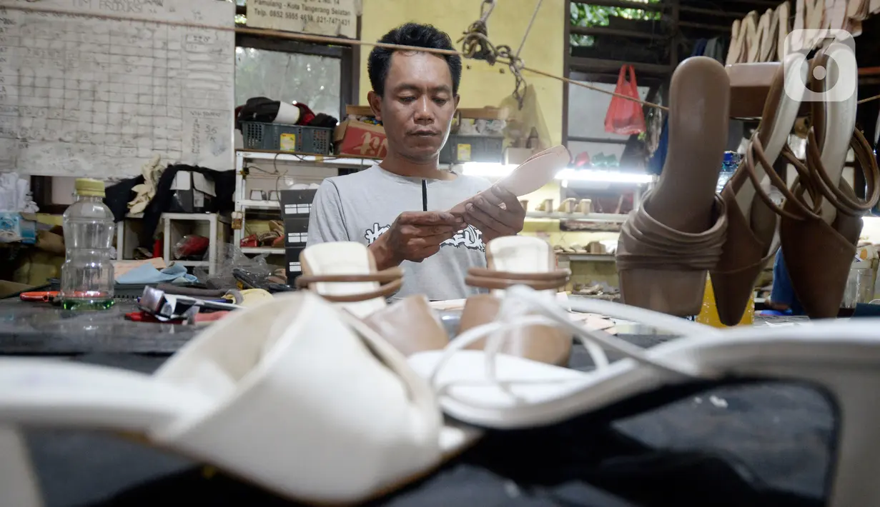 Pekerja sedang menyelesaikan produksi home industri sepatu wanita pesanan pembeli di Pamulang, Tangerang Selatan, Banten,  Rabu (14/10/2020). Pada masa pandemi ini pemesanan sepatu turun 40 persen dibandingkan sebelum Covid-19. (merdeka.com/Dwi Narwoko)