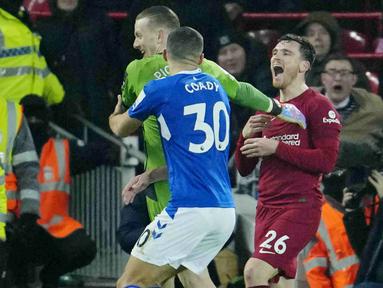 Pemain Liverpool, Andrew Robertson, menertawakan kiper Everton, Jordan Pickford, pada laga Liga Inggris di Stadion Anfield, Selasa (14/2/2023). Derby Merseyside selalu diwarnai tensi panas. (AP Photo/Jon Super)