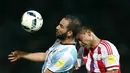 Pemain Argentina Gonzalo Higuan berebut bola dengan pemain Paraguay Paulo Da Silva pada pertandingan kualifikasi Piala Dunia 2018 di Stadion Mario Kempes, Cordoba, Argentina (11/10). (REUTERS/Marcos Brindicci)