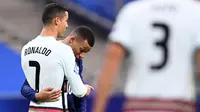 Striker Portugal, Cristiano Ronaldo, berbincang dengan striker Prancis, Kylian Mbappe, pada laga UEFA Nations League di Stadion Stade de France, Senin (12/10/2020). Kedua tim bermain imbang 0-0. (AFP/Franck Fife)