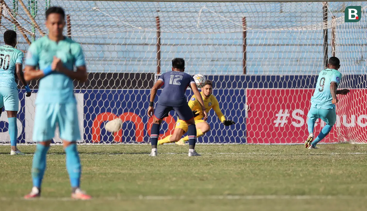Pemain Madura United, Alberto Goncalves (kanan) melakukan eksekusi penalti yang berbuah gol pertama timnya ke gawang Arema FC dalam laga pekan ke-16 BRI Liga 1 2022/2023 di Stadion Sultan Agung, Bantul, Yogyakarta, Selasa (20/12/2022) sore WIB. (Bola.com/Ikhwan Yanuar)