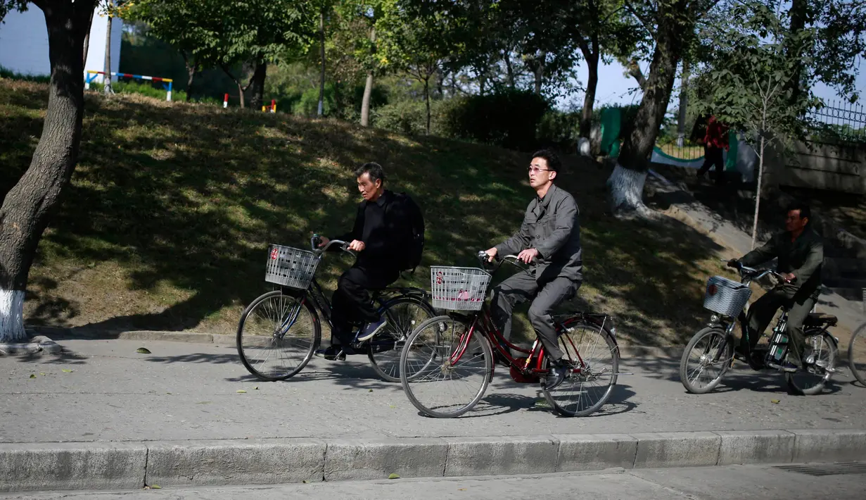 Sejumlah pria Korea Utara mengendarai sepeda mereka di Pyongyang, Korea Utara, (21/10).  (AP Photo / Dita Alangkara)