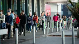 Orang-orang mengantre pada pagi hari di luar supermarket ketika Selandia Baru bersiap ke pembatasan level 3 di Hobsonville, Auckland, Rabu (12/8/2020). Selandia Baru akan memberlakukan lockdown di Auckland setelah ditemukan 4 kasus baru COVID-19 di kota itu. (Dean Purcell/New Zealand Herald via AP)