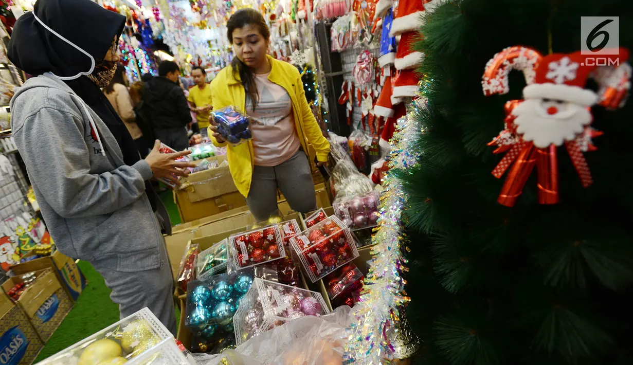 Pembeli memilih pernak-pernik perayaan Natal di Pasar Asemka, Jakarta,Kamis (13/12). Pedagang mengaku penjualan pernak-pernik Natal meningkat dari minggu sebeumnya. (Merdeka.com/Imam Buhori)
