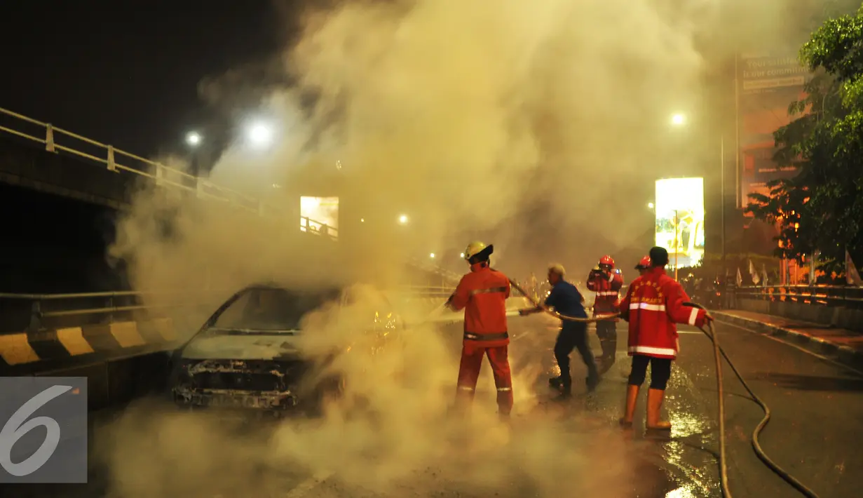 Petugas memadamkan api saat mobil terbakar di jembatan layang Slipi, Jakarta, Rabu (17/5). Penyebab kebakaran masih dalam penyelidikan petugas (Liputan6.com/Gempur M Surya)