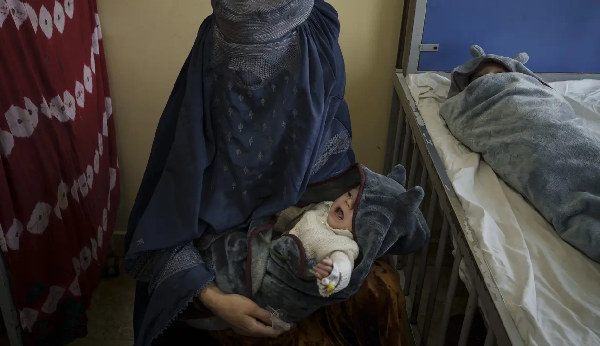 Seorang perempuan menggendong salah satu dari dua bayinya di bangsal gizi buruk Rumah Sakit Anak Indira Gandhi di Kabul, Selasa (5/10/2021). UNICEF menyebut hampir dua juta anak-anak Afghanistan berisiko kekurangan gizi karena kemiskinan akut di tengah lonjakan harga bahan makanan. (AP/Felipe Dana)