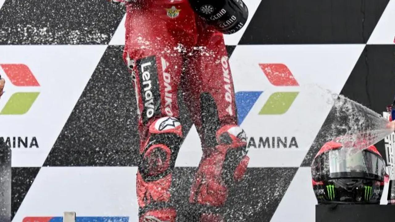 Pecco saat merayakan juara di podium.