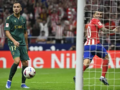 Penyerang Atletico Madrid #10 Angel Correa (kanan) merayakan gol ketiga untuk timnya yang dicetak ke gawang Cadiz pada laga lanjutan Liga Spanyol di Estadio Wanda Metropolitano, Senin (2/10/2023) dini hari WIB. (JAVIER SORIANO / AFP)