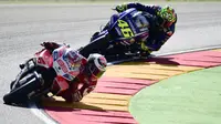 Pembalap Ducati Team, Jorge Lorenzo (depan) bersaing dengan pembalap Movistar Yamaha, Valentino Rossi pada balapan MotoGP Aragon di Spanyol, Minggu (24/9). Rossi kembali dan tampil di MotoGP Aragon usai jalani pemulihan selama 25 hari. (JOSE JORDAN/AFP)