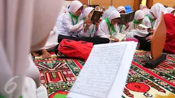 Sejumlah santri membaca ayat suci Al Quran di Gedung Pertamina, Jakarta, Kamis (23/6). Dalam rangka peringatan Nuzulul Quran, Pertamina bersama 27.218 anak yatim se-Jakarta membaca kitab suci Al Quran hingga khatam. (Liputan6.com/Angga Yuniar)