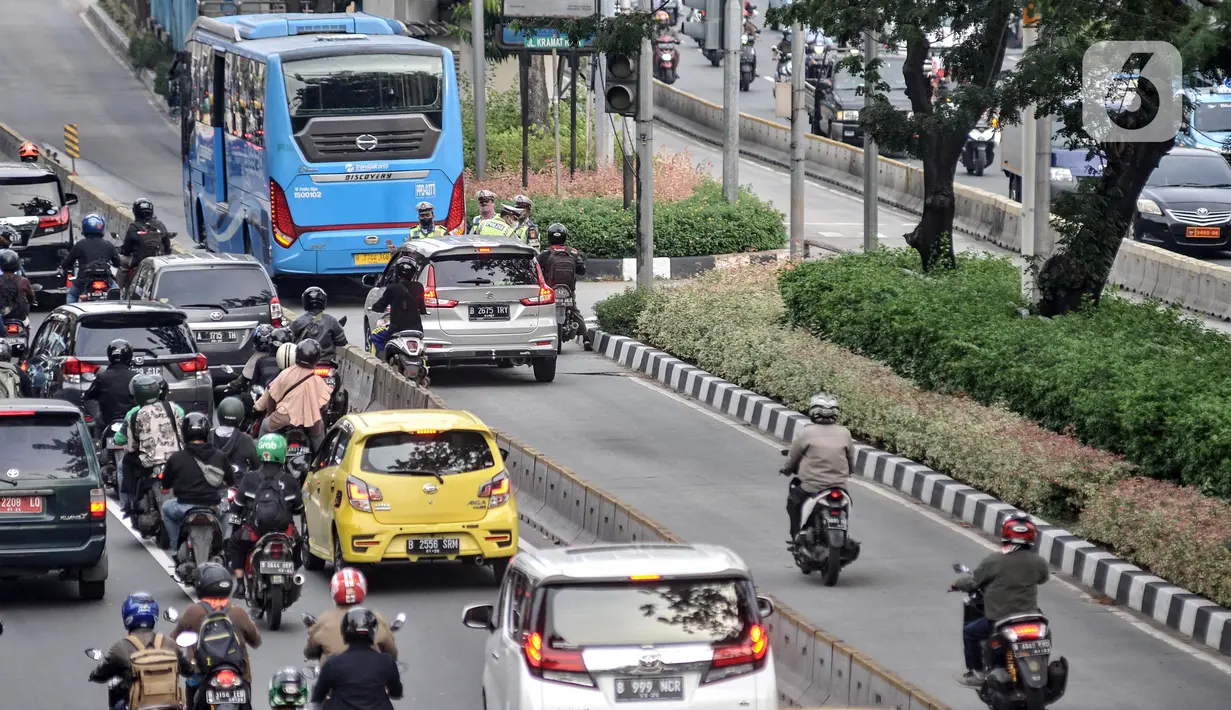 Anggota Satlantas Polres Metro Jakarta Pusat memberhentikan pengendara yang menerobos jalur Bus Transjakarta di Jalan Kramat Raya, Kecamatan Senen, Jakarta, Kamis (21/7/2022). Razia digelar untuk menindak para pengendara yang tidak disiplin demi menghindari kemacetan serta mencegah terjadi kecelakaan di jalur Bus Transjakarta. (merdeka.com/Iqbal S. Nugroho)