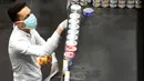 Seorang pria dengan masker dan sarung tangan berbelanja saat orang-orang mulai membeli persediaan di supermarket di Beirut, Rabu (11/3/2020). Total 61 orang yang dinyatakan positif virus Corona di Lebanon dimana pasien pertama sudah dinyatakan sembuh dan terbebas dari virus itu. (AP/Hussein Malla)