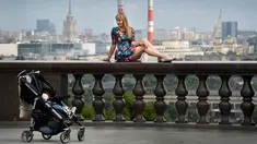Seorang wanita berpose di perbukitan Vorobyovy di Moskow, Rusia (12/7). Dengan berpose di perbukitan Vorobyovy pengunjung dan wisatawan bisa mengambil latar belakang kota di Moskow. (AFP Photo/Alexander Nemenov)