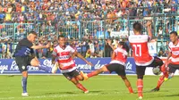 Striker Arema Cronus, Cristian Gonzales melepaskan tembakan ke gawang Madura United dalam laga yang berakhir dengan skor 2-1 di Stadion Kanjuruhan, Malang, Minggu (14/2/2016). (Bola.com/Kevin Setiawan)