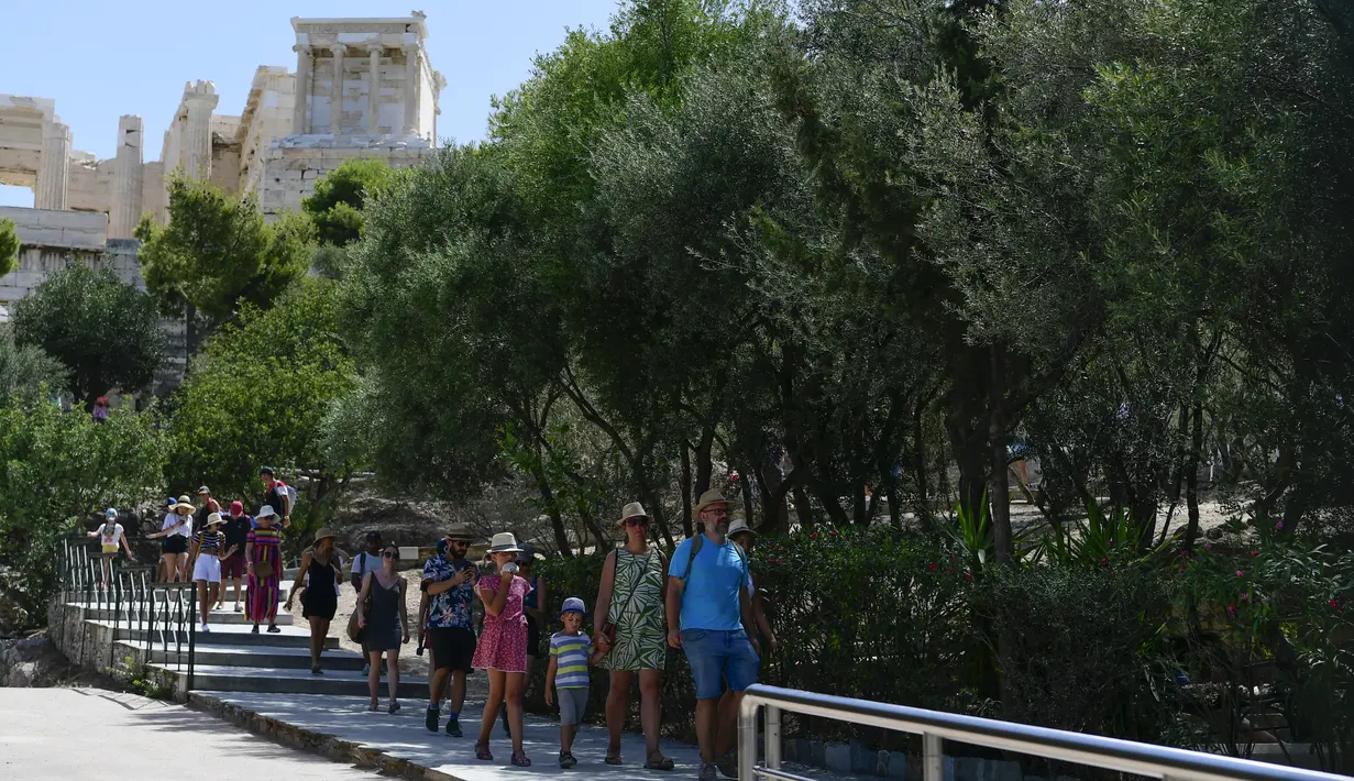 Turis keluar dari Acropolis kuno, di Athena Yunani, Selasa (3/8/2021). Suhu mencapai 42 C (107,6 F) di beberapa bagian ibu kota Yunani, karena cuaca ekstrem memicu kebakaran hutan yang mematikan di Turki dan berkobar di seluruh wilayah. (AP Photo/Michael Varaklas)