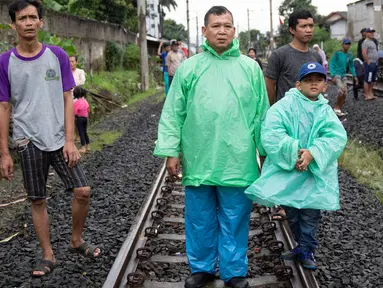 Warga melihat proses evakuasi KRL yang anjlok di kawasan Kebon Pedes, Bogor, Jawa Barat, Minggu (10/3). Kepala Daop I Jakarta Dadan Risdiansyah memastikan penanganan KRL yang anjlok selesai hari ini. (Liputan6.com/Immanuel Antonius)
