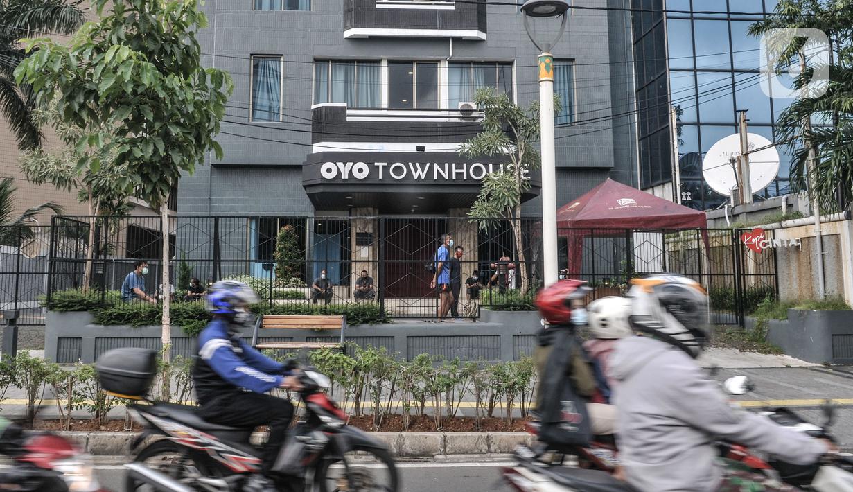 Pengendara motor melintas di depan pasien Covid-19 yang sedang berjemur di sebuah hotel kawasan Salemba, Jakarta, Senin (22/2/2021). Para pasien Covid-19 memilih hotel dengan alasan lebih nyaman dan privasi dibandingkan rumah sakit meskipun mengeluarkan biaya lebih.  (merdeka.com/Iqbal S. Nugroho)