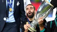 Bek Real Madrid, Dani Carvajal berpose dengan trofi Piala Super Eropa usai timnya menumbangkan Manchester United (MU) di Skopje, Macedonia, Selasa (8/8). Real Madrid mengalahkan Manchester United dengan skor 2-1. (Dimitar DILKOFF / AFP)