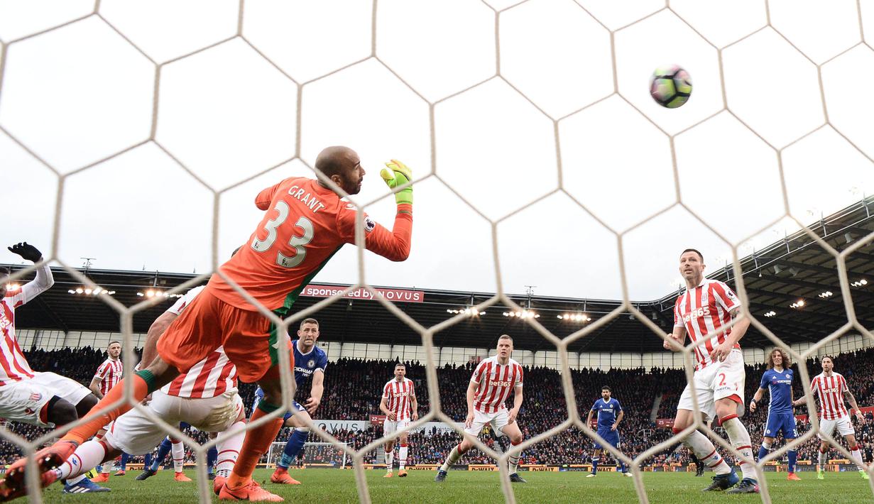 Bek Chelsea, Gary Cahill, menendang bola ke arah gawang kiper Stoke City, Lee Grant. Gol Gary Cahill, pada menit-menit terakhir membawa Chelsea menang 1-2 atas Stoke City. (AFP/Oli Scarff).