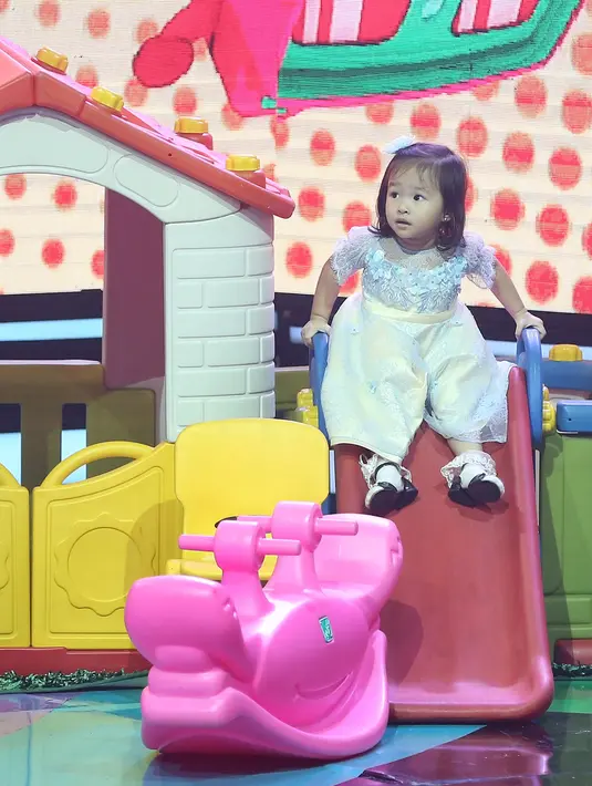 Tidak hanya menerima piala kemenangan di atas panggung, tapi Thalia juga terlihat lucu banget saat bermain. Dengan lucunya Thalia bermain di perosotan dengan gaun yang dipakainya. (Bambang E.Ros/Bintang.com)