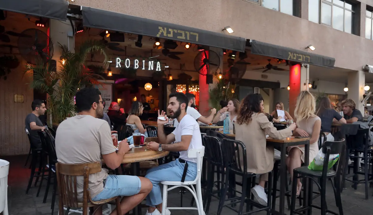 Orang-orang berkumpul di Abima Square di kota Tel Aviv, Israel (20/5/2021).  Israel dan dua kelompok bersenjata utama Palestina di Gaza, Hamas dan Jihad Islam, menyetujui gencatan senjata untuk mengakhiri konflik selama 11 hari. (AFP/Gideon Markowicz)