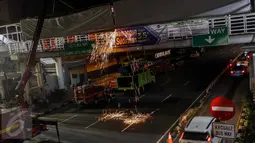 Kendaraan berat crane diterjunkan untuk membantu proses pembongkaran papan reklame yang terpasang di JPO kawasan Salemba, Jakarta, Rabu (26/10) malam. Pembongkaran dilakukan lantaran  papan reklame itu diketahui tidak berizin. (Liputan6.com/Faizal Fanani)