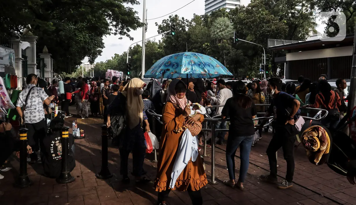 Warga memanfaatkan libur tahun baru 2023 dengan mengunjungi kawasan Monumen Masional (Monas), Jakarta, Minggu (1/1/2023). Monas menjadi salah satu destinasi wisata favorit warga baik dari Jakarta, maupun luar ibu kota, untuk menikmati liburan tahun baru. (Liputan6.com/Johan Tallo)