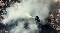Seorang pengunjuk rasa menggunakan alat pemadam kebakaran saat bentrok dengan polisi anti huru hara dalam menentang kudeta militer di Yangon (28/2/2021). Sedikitnya 18 orang tewas setelah Polisi Myanmar menembaki pengunjuk rasa di seluruh negeri pada hari Minggu. (AFP/Sai Aung Main)