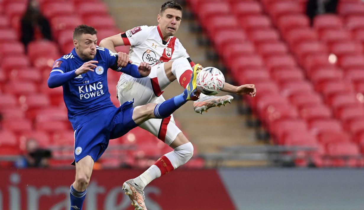 Striker Leicester City, Jamie Vardy, berebut bola dengan pemain Southampton, Jan Bednarek, pada laga Piala FA di Stadion Wembley, Senin (19/4/2021). Leicester City menang dengan skor 1-0. (John Sibley/Pool via AP)
