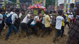 Sejumlah pria dari suku India Pnar memikul kereta kayu atau 'Rongs' saat Festival Behdienkhlam di desa Tuber, India (24/7). Festival ini digelar untuk mengusir wabah penyakit serta mengharapkan hasil panen yag melimpah. (AP Photo/Anupam Nath)