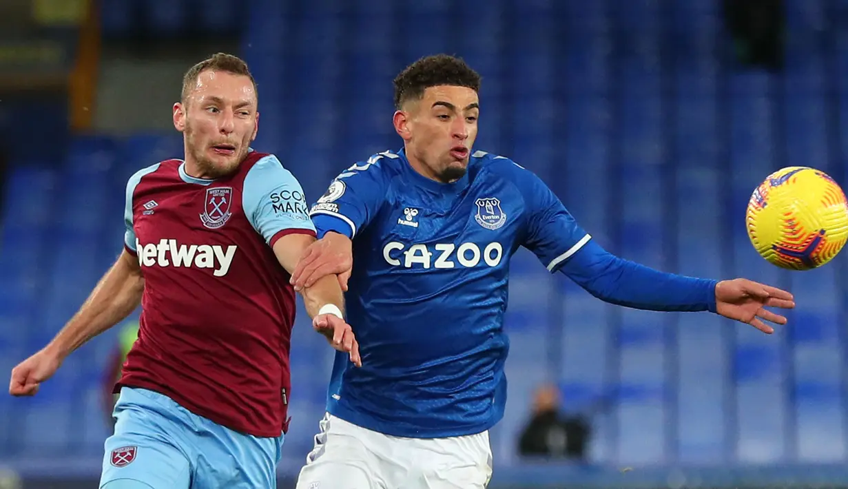 Pemain Everton, Ben Godfrey (kanan) tidak memiliki tipikal bek tengah seperti pada umumnya. Fisiknya tidak terlalu kekar dan tinggi badannya hanya mencapai 1,83 meter. Namun, kemampuannya dalam berlari tak pernah diragukan lagi. Ia mampu menempel penyerang berkecepatan tinggi. (AFP/Pool/Peter Byrne)
