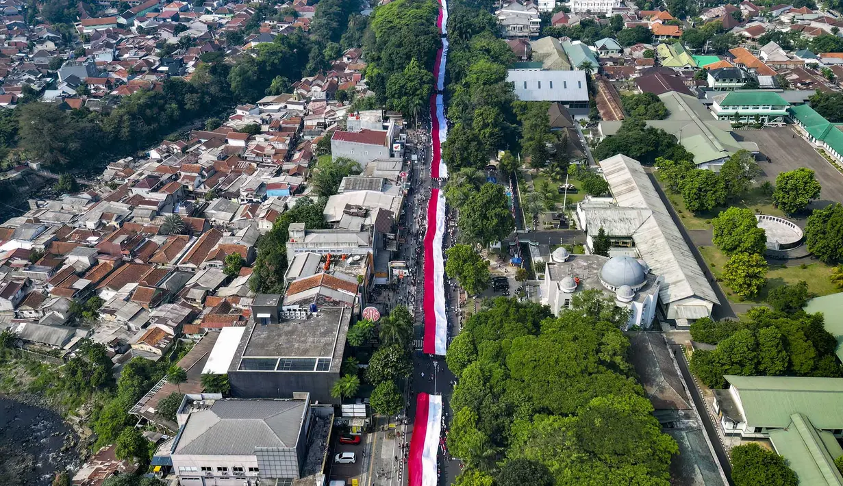 Foto udara ini memperlihatkan sekitar 3.500 orang yang berpartisipasi dalam pawai membawa bendera Indonesia sepanjang 500 meter di Jalan Sudirman Bogor, Jawa Barat, Minggu,  9 Agustus 2026. (AFP/ Aditya Aji)
